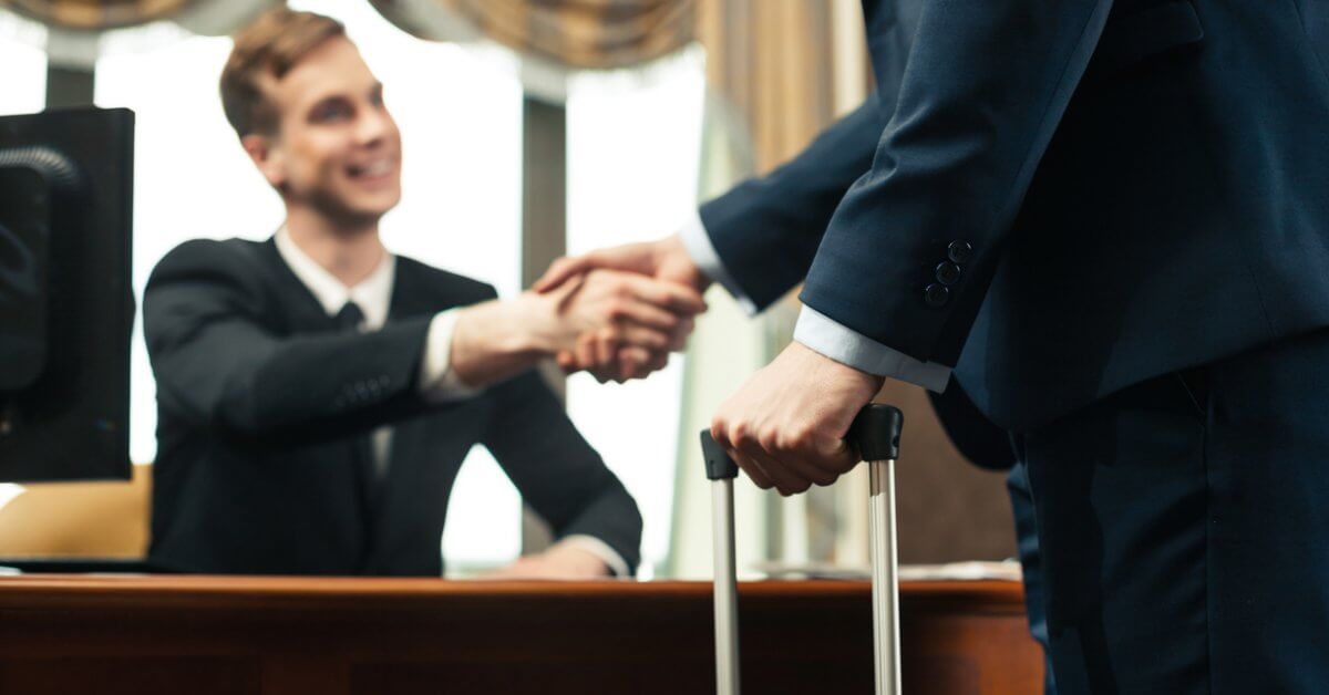 Übersicht zum dualen Studium Junger Front Office Manager schüttelt Gast die Hand